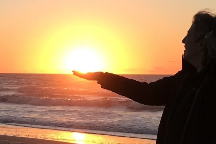 Nancy Berlove appearing to hold the sun in her hands